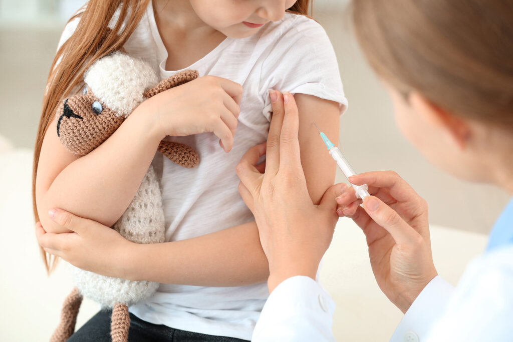Doctor vaccinating little girl in clinic
