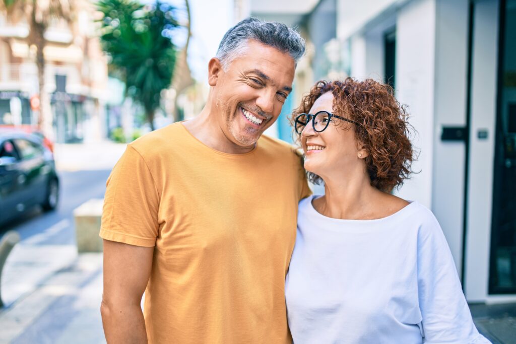 Middle age couple smiling happy standing at street of city.